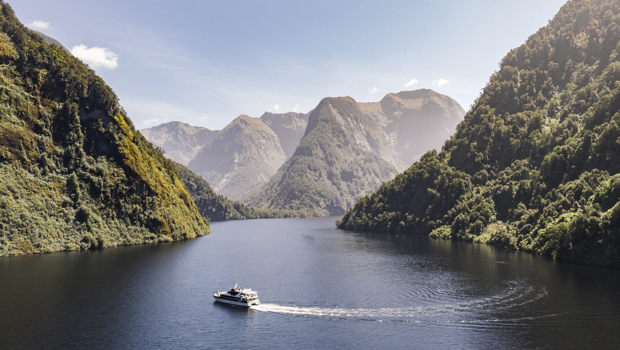 Image of a boat navigating a wide, jungle-lined river